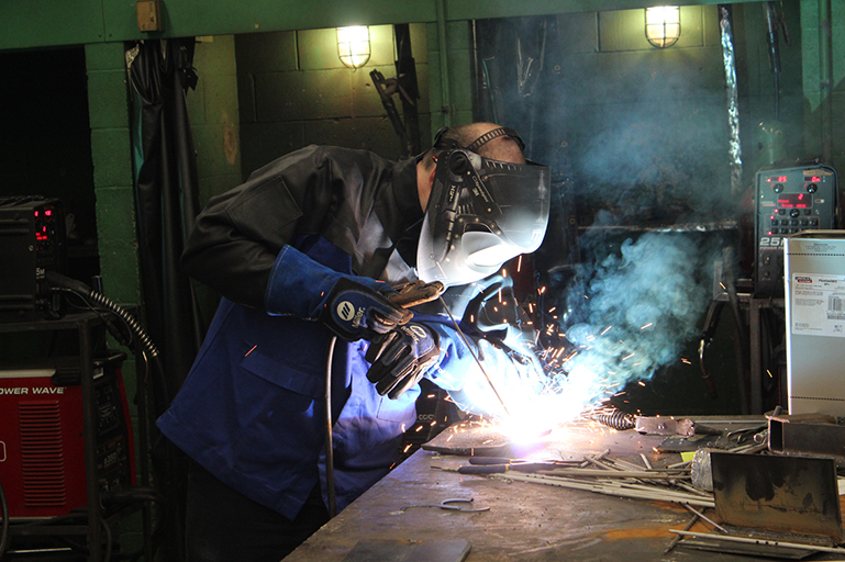 A male student welding metal materials