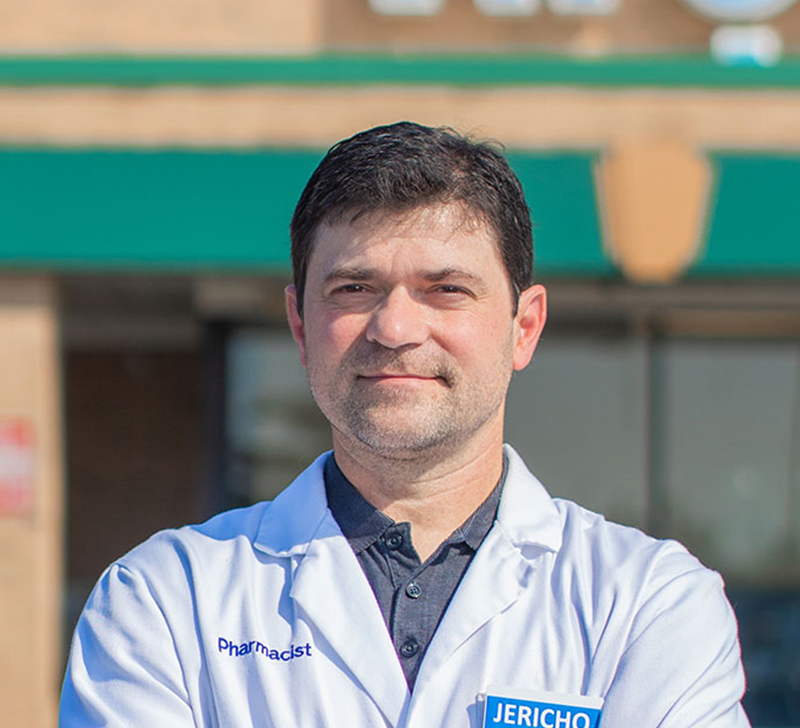 man in doctor's white coat standing in front of a building