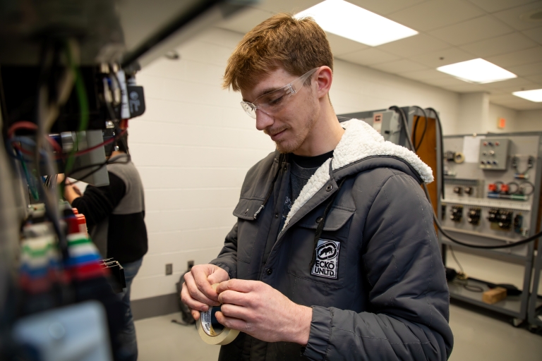 male student looking at electric tape