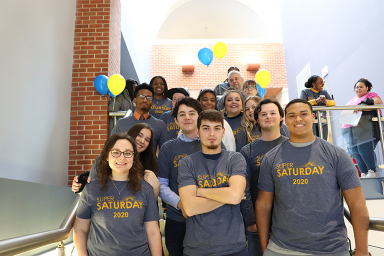 group of students standing on the stairs wearing t-shirt for Super Saturday 2020 event