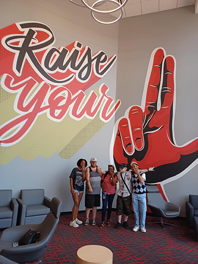 "Raise Your Hand" image on wall with ECTC group at University of Louisville event