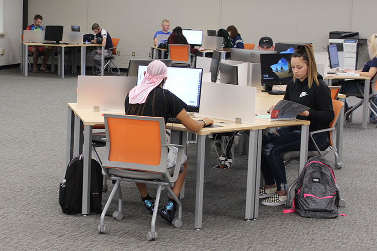 students sitting at tables in the library