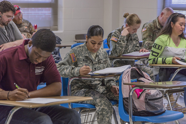 Three military students in classroom with other students