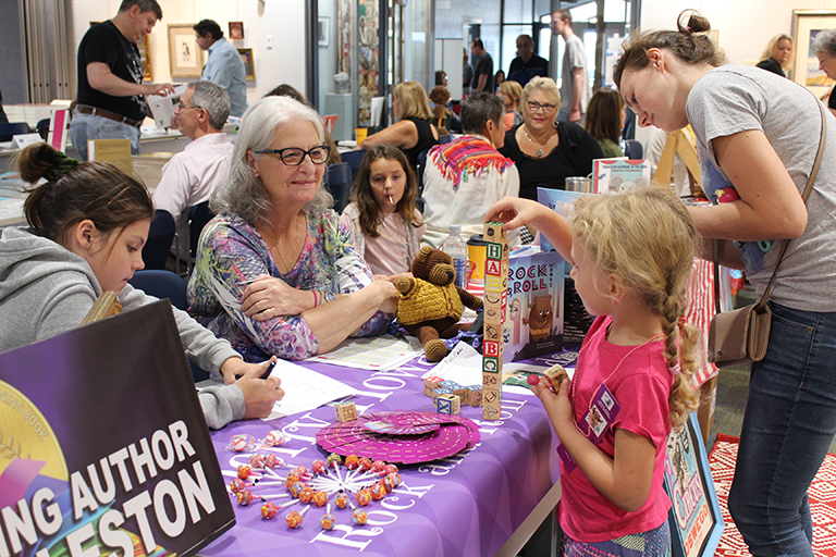 Authors with visitors looking at books