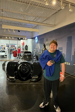 Person in front of an art photo of a car