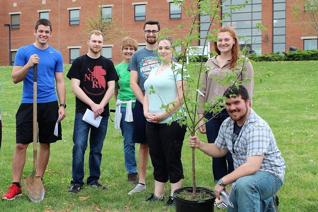 Students and faculty planting a tree