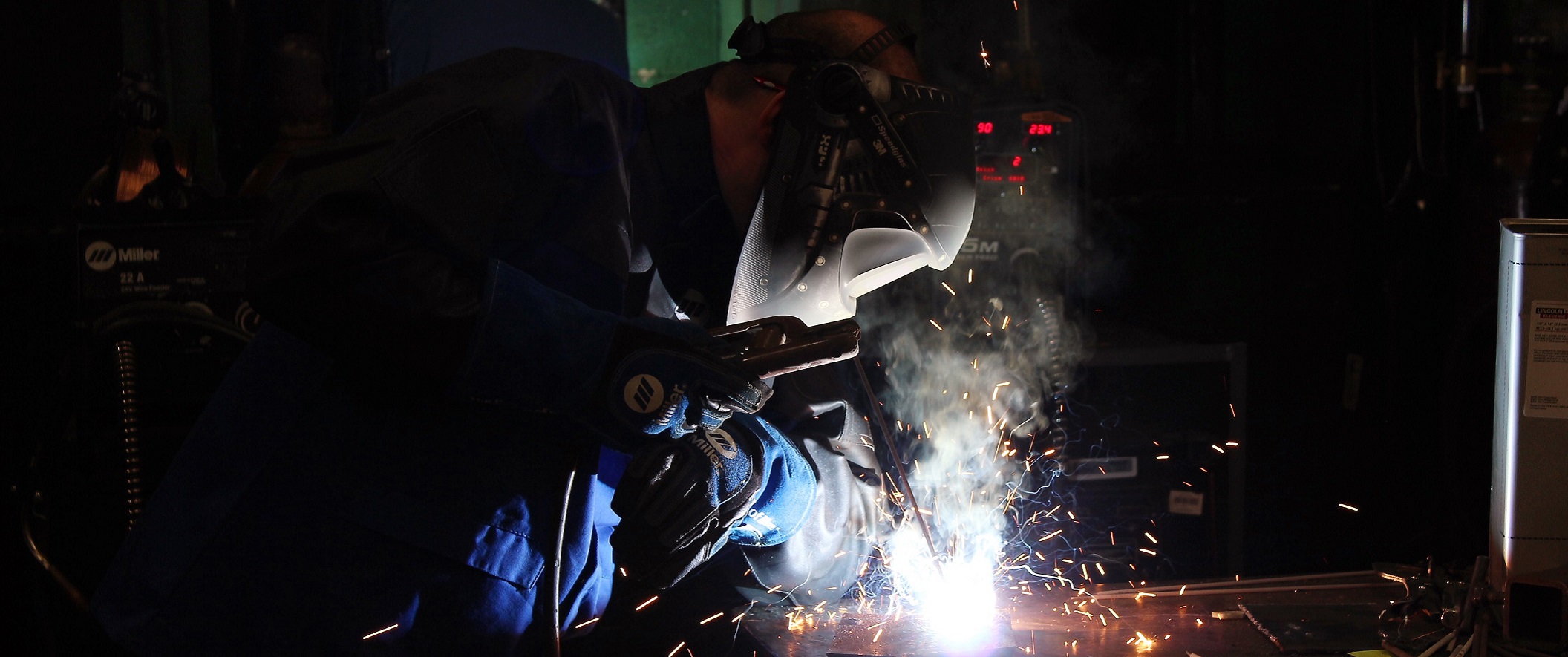 Student welding in a dark room