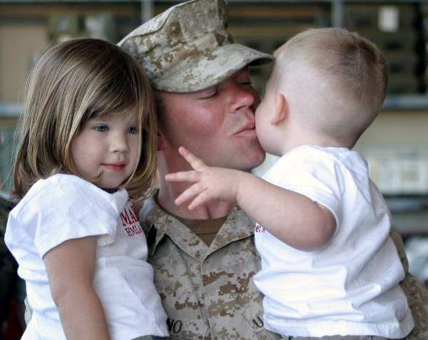 Service member holding small children