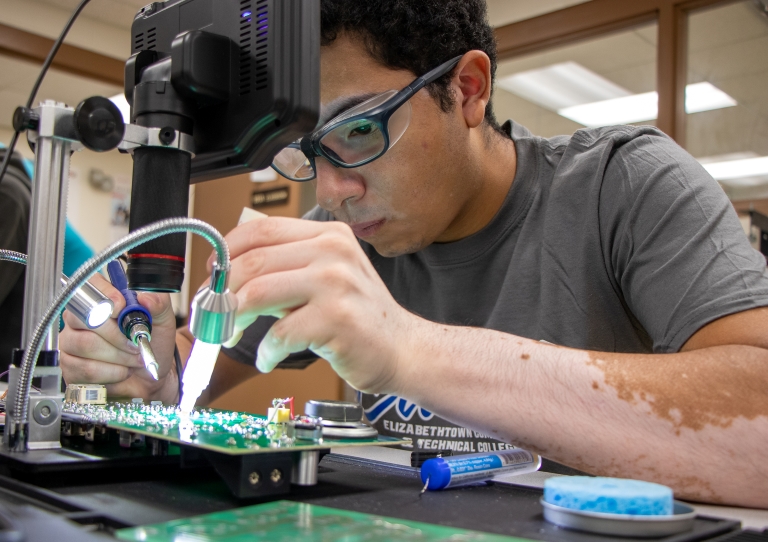 student working on a circuit board