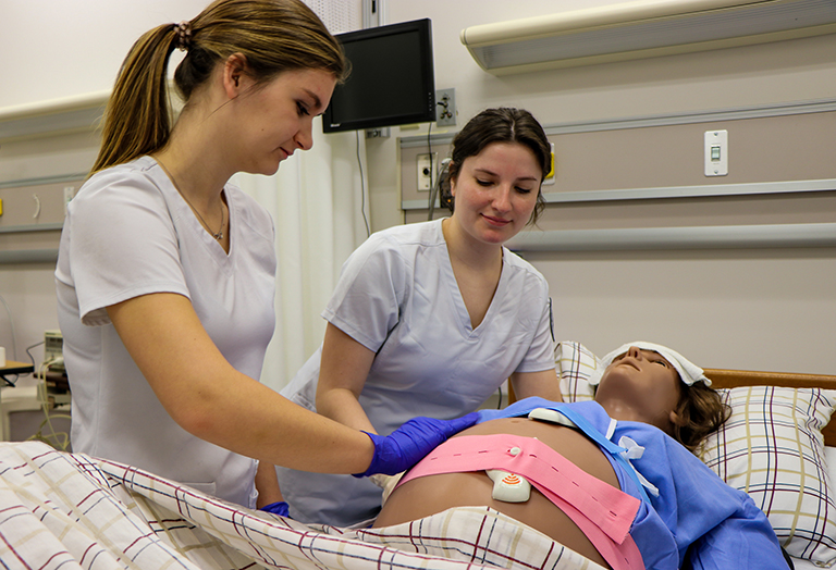 Two nurses testing new labor mannequin